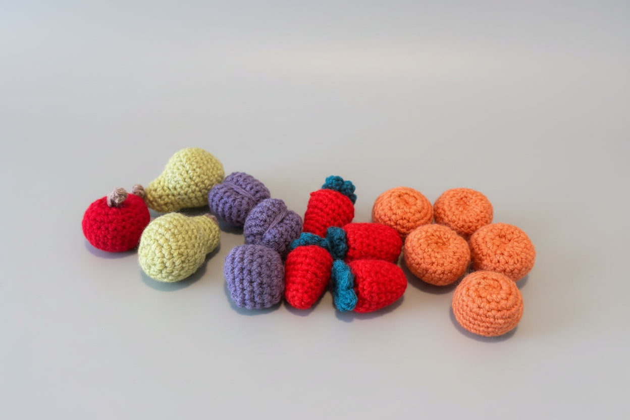 Colorful crocheted fruits and vegetables on a wooden surface