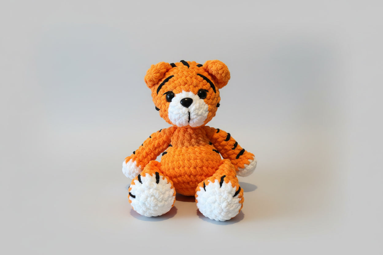 Plush tiger toy on a wooden surface with stone wall background
