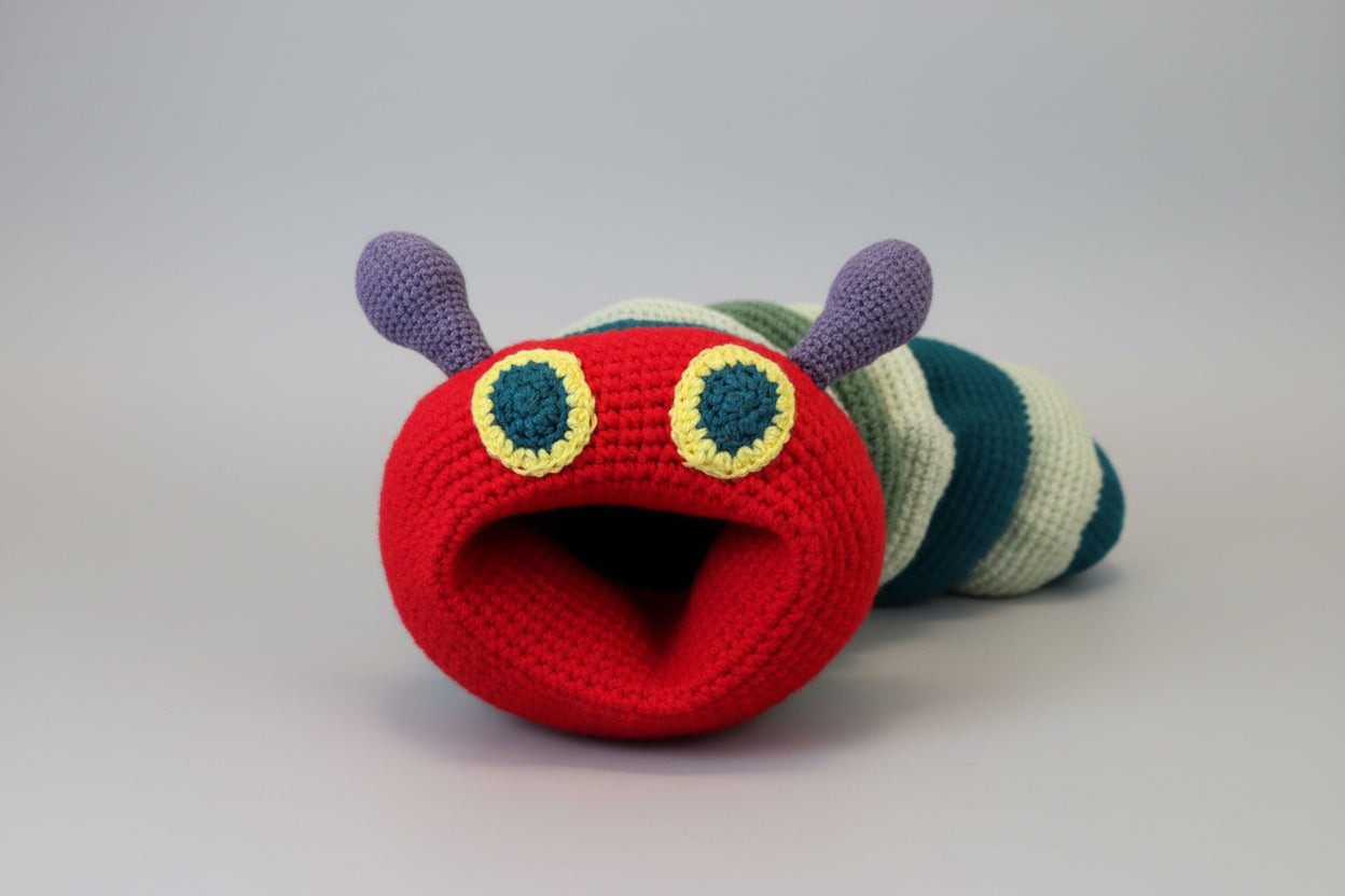 Colorful crocheted caterpillar toy on a wooden surface